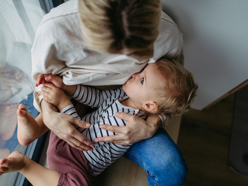 Mamma che allatta un bambino più grande, durante un momento di vicinanza e contatto.